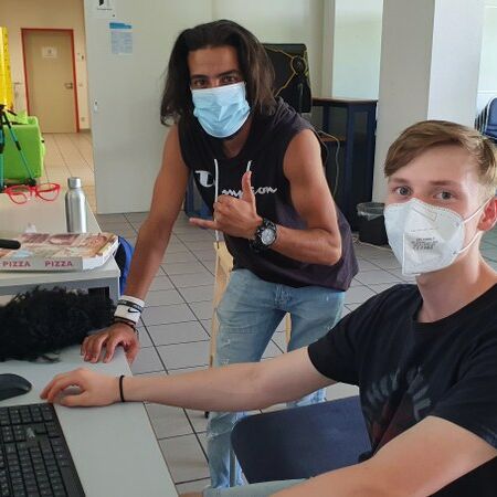 Zwei Jugendliche mit Mundschutz am Computer